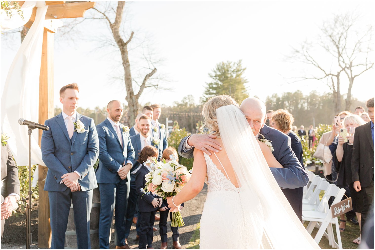 father giving bride away during outdoor ceremony at Renault Winery in Egg Harbor Township, NJ