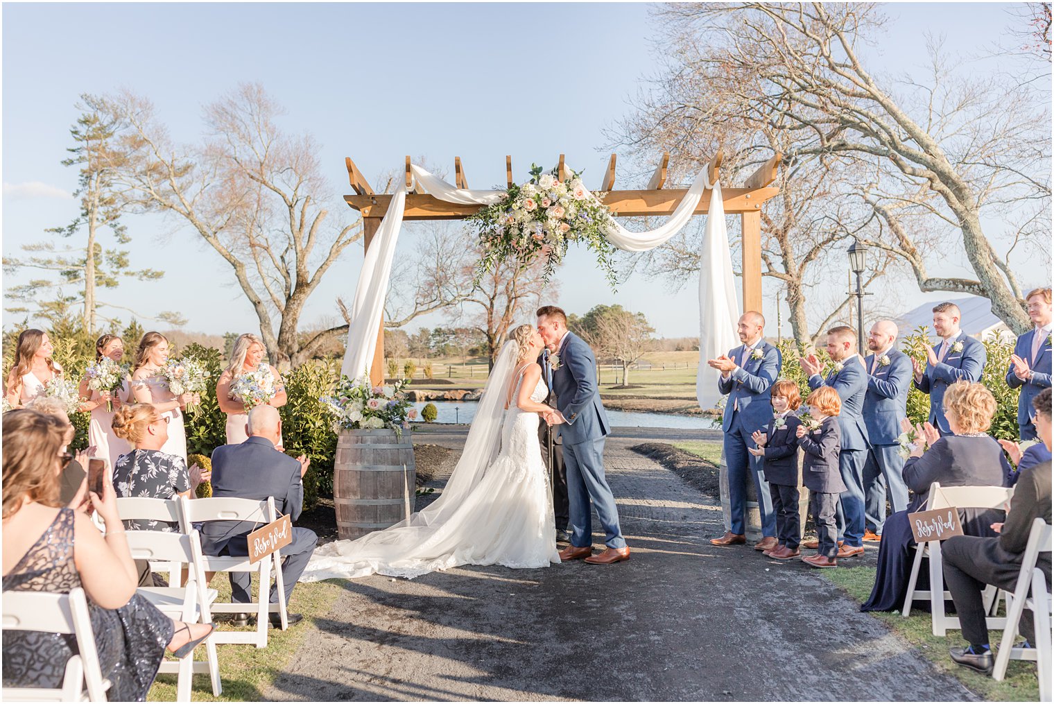 bride and groom kissing during outdoor ceremony at Renault Winery in Egg Harbor Township, NJ