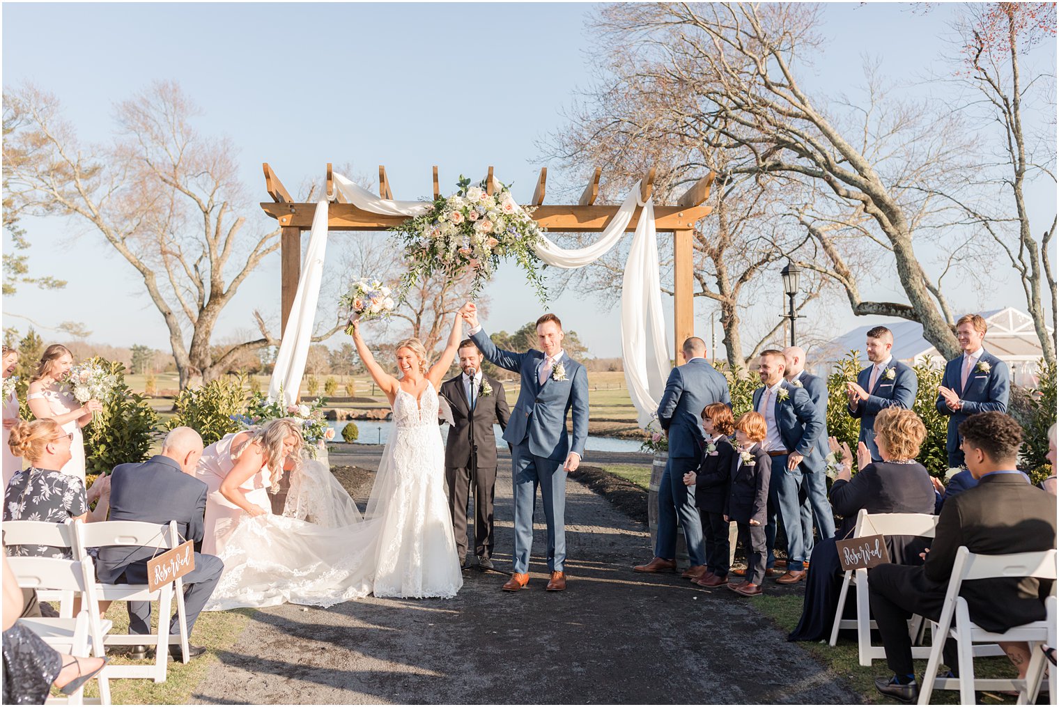 bride and groom cheering after kiss during outdoor ceremony at Renault Winery in Egg Harbor Township, NJ