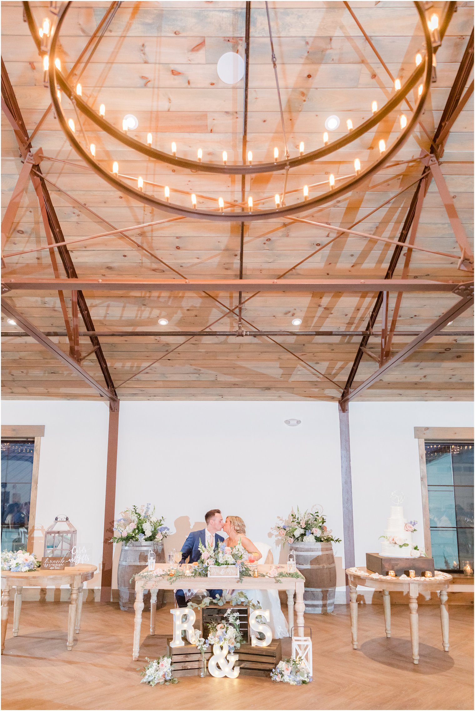 bride and groom at sweetheart table at rustic wedding reception in Vineyard Ballroom at Renault Winery South Jersey Venue in Egg Harbor Township NJ