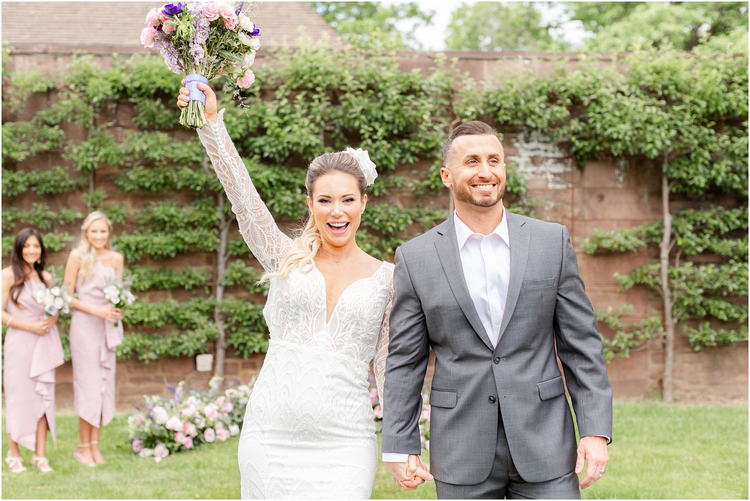 bride cheers with bouquet in the air after ceremony in Tyler Gardens