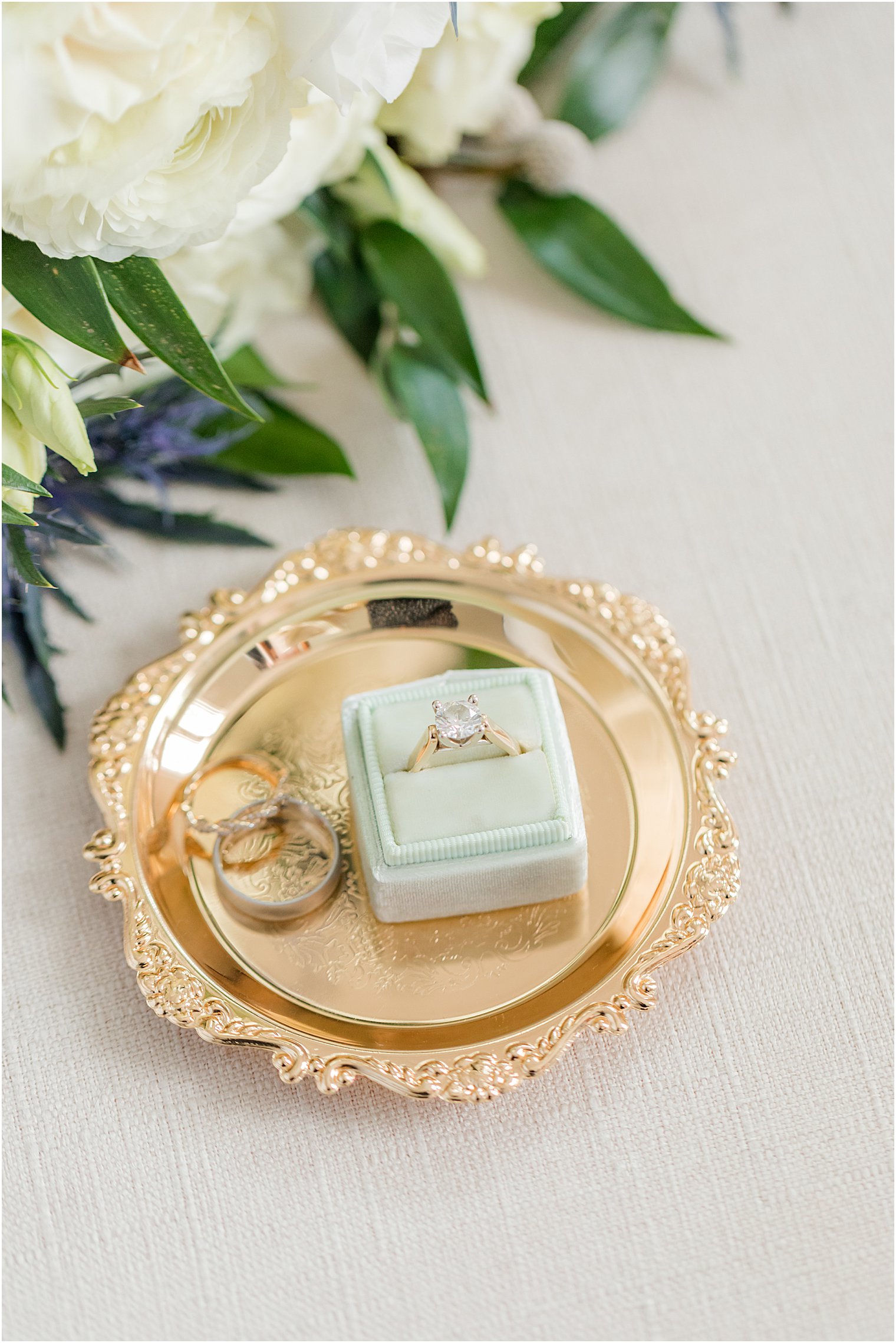 wedding rings rest on gold tray before NJ wedding