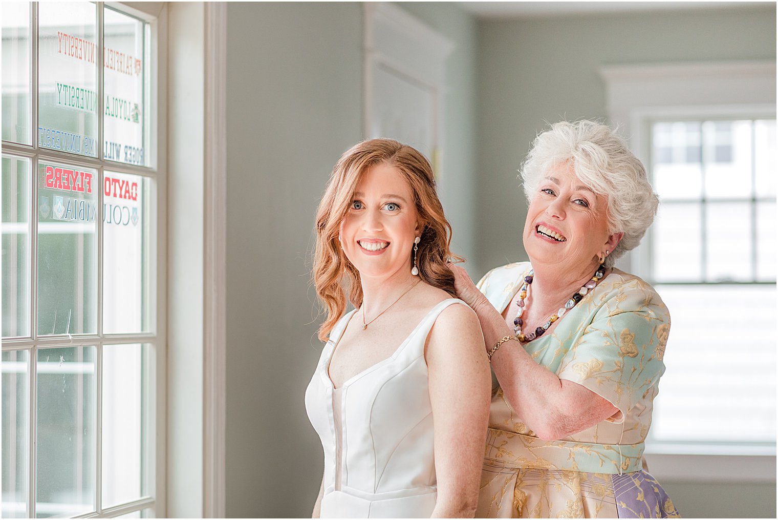 mother helps bride with necklace 