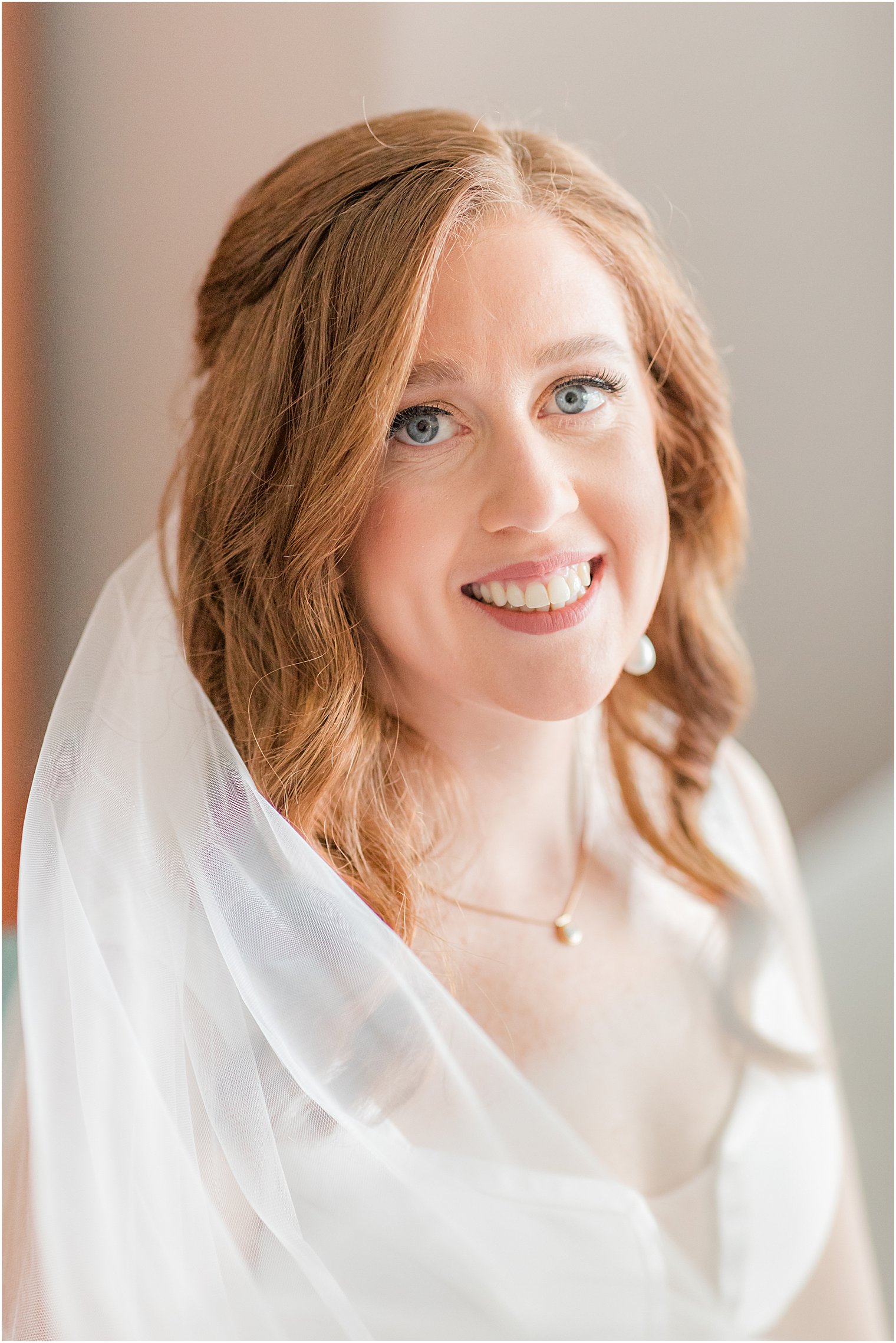 bride smiles with veil around shoulder before Belmar Fishing Club wedding