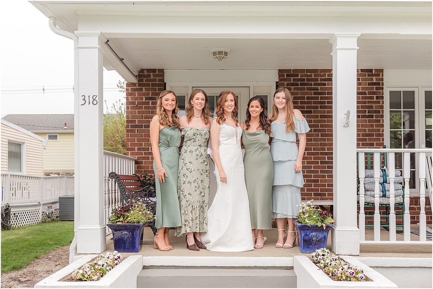 bride poses with bridesmaids in mismatched gowns before Belmar Fishing Club wedding