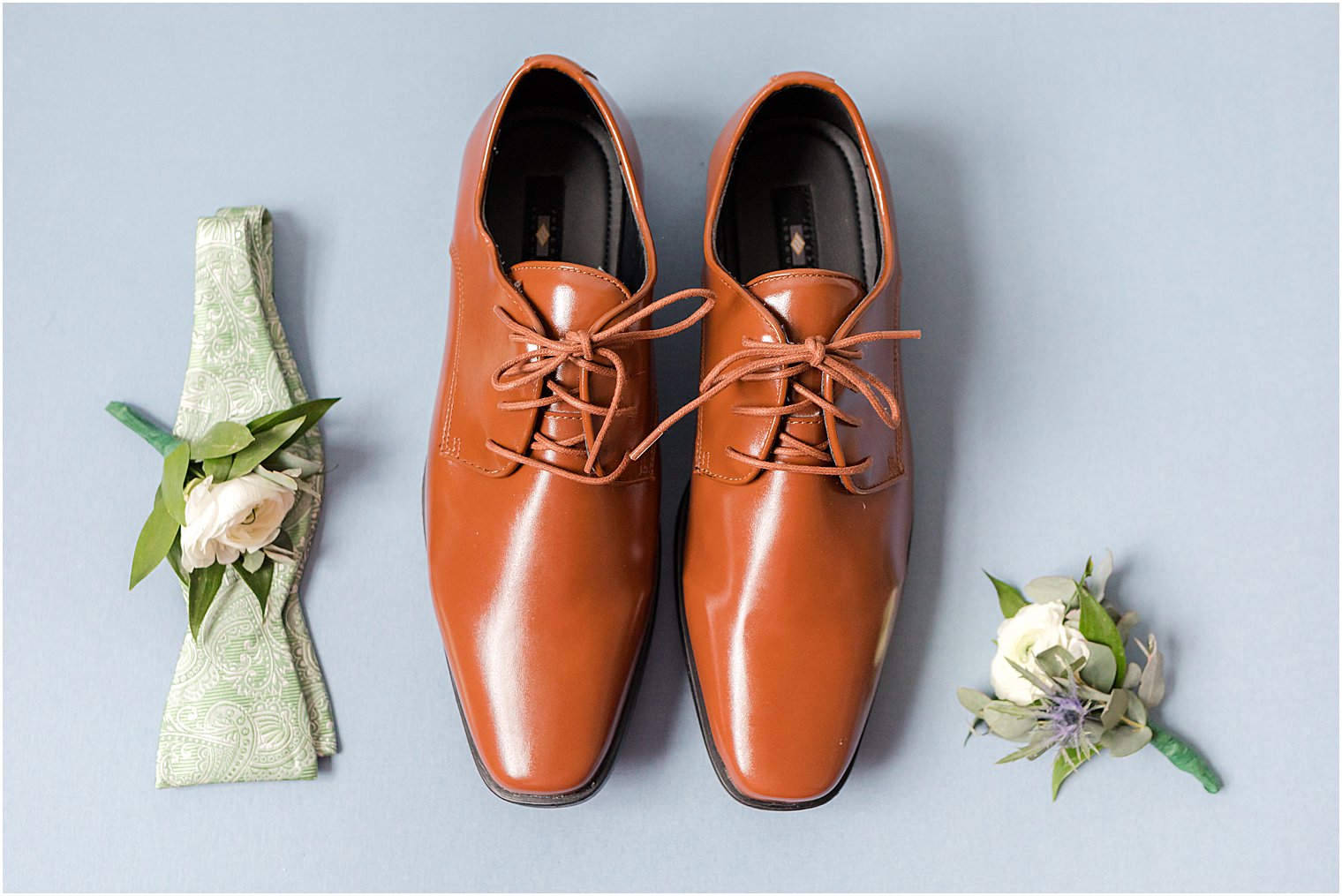 groom's brown shoes and floral boutonnières
