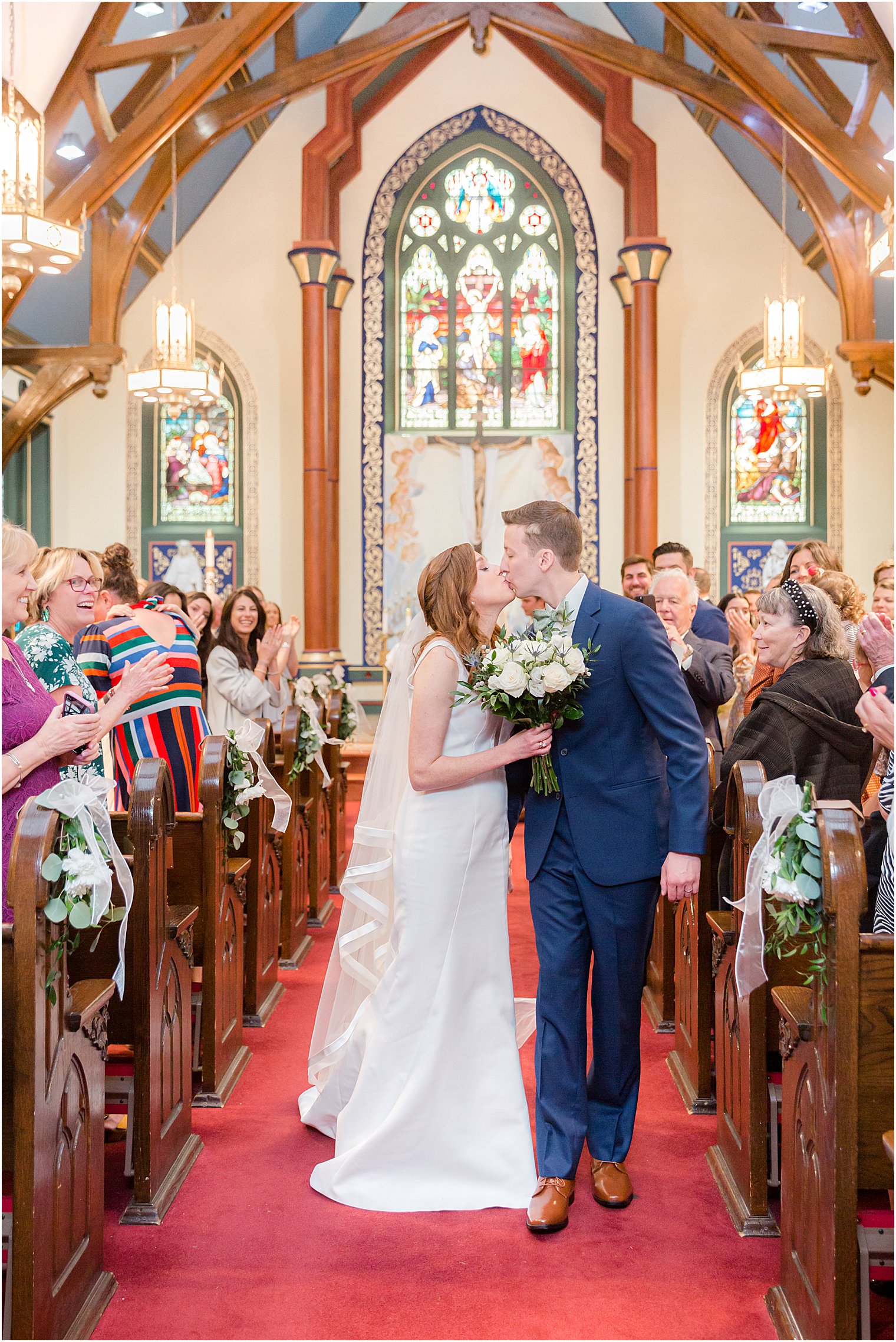 newlyweds kiss in aisle after traditional church ceremony at Avon-by-the-Sea