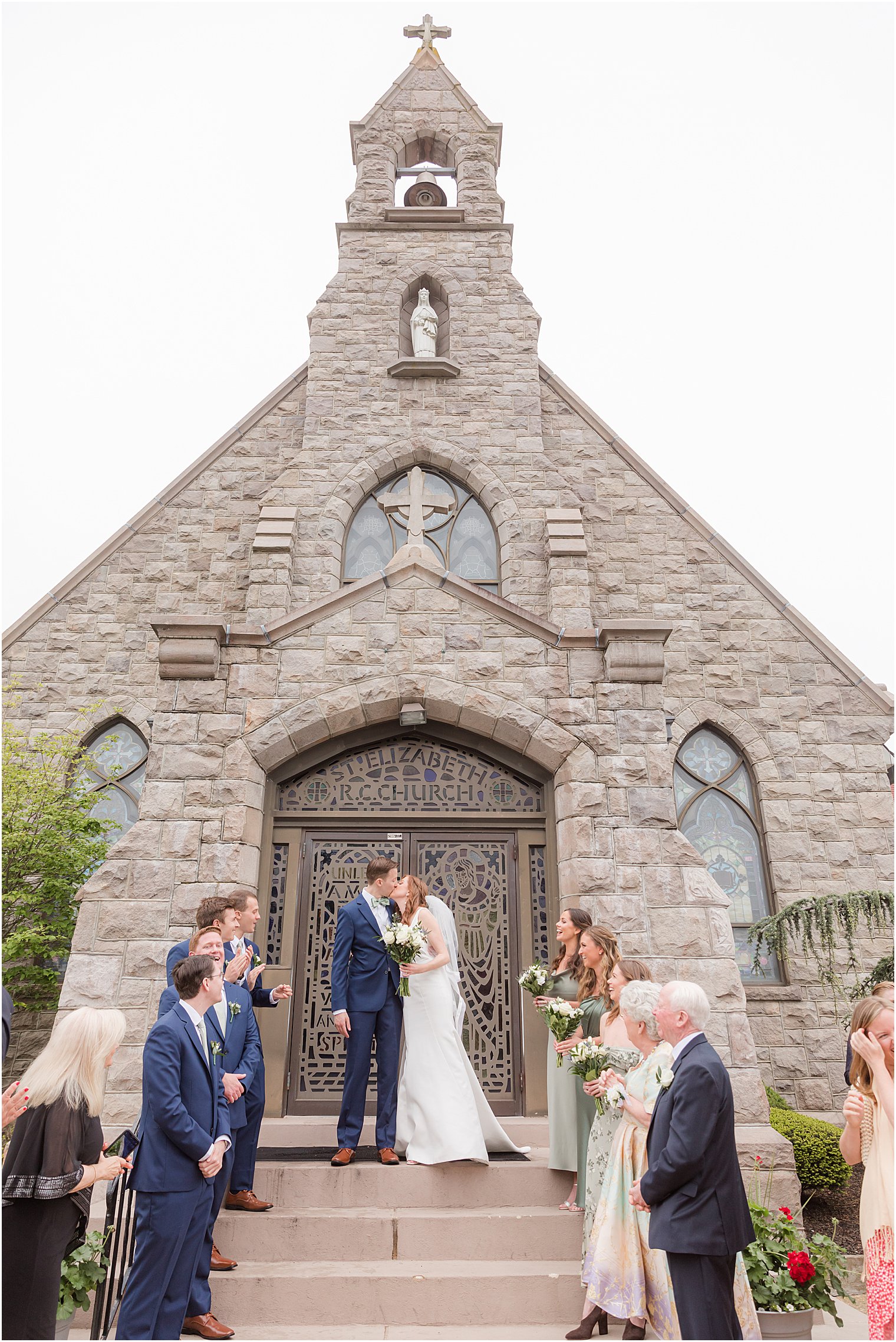 bride and groom kiss on steps outside Avon-by-the-Sea