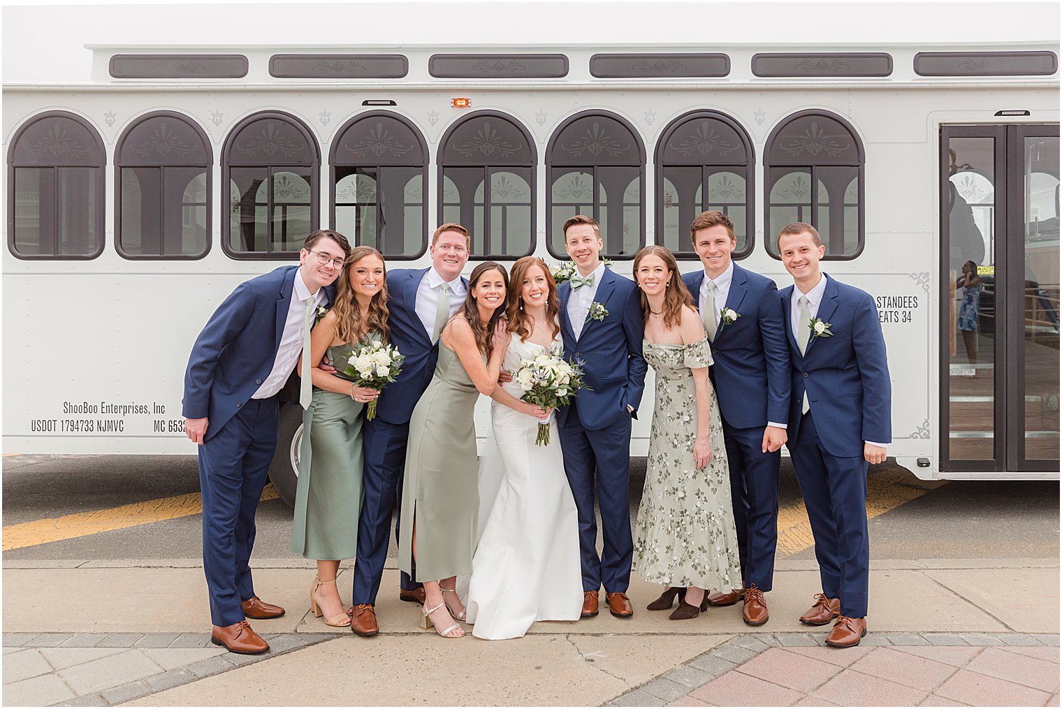 couple hugs while bridal party poses with them