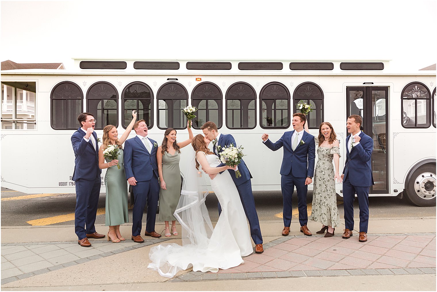 newlyweds kiss outside white trolley during NJ wedding photos