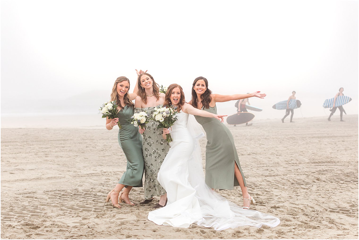 bride and bridesmaids pose on foggy beach