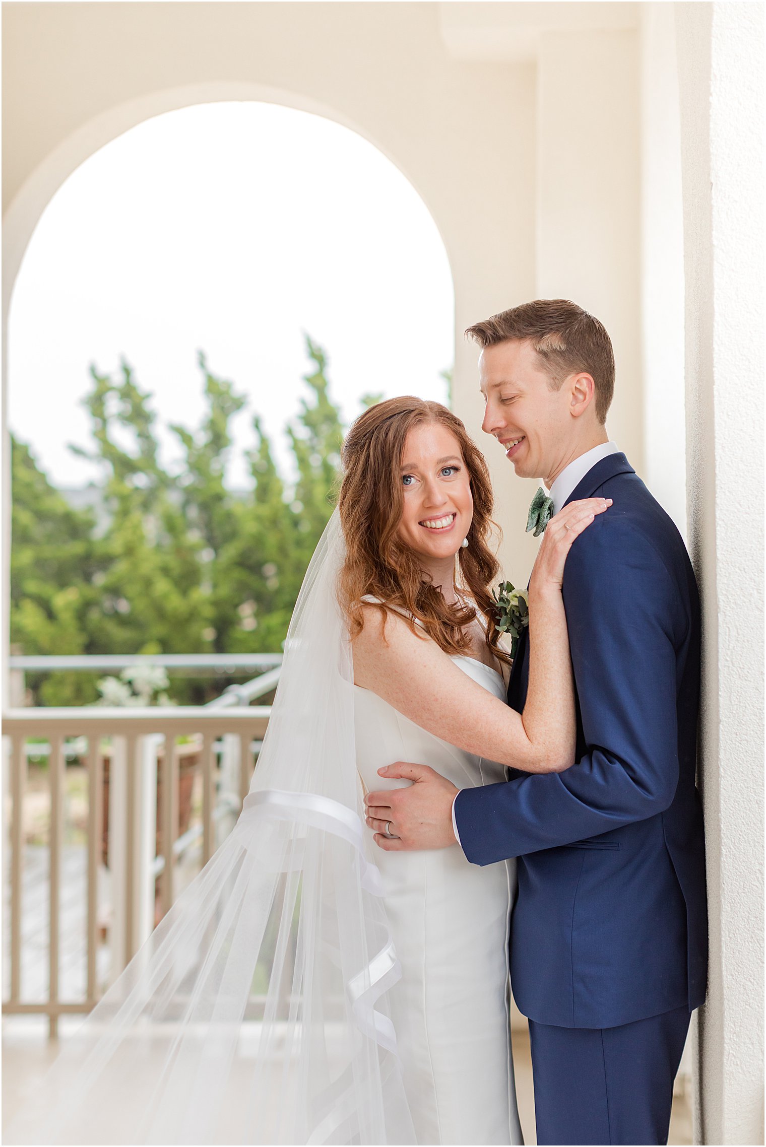 bride hugs groom's shoulders during Belmar Fishing Club wedding photos