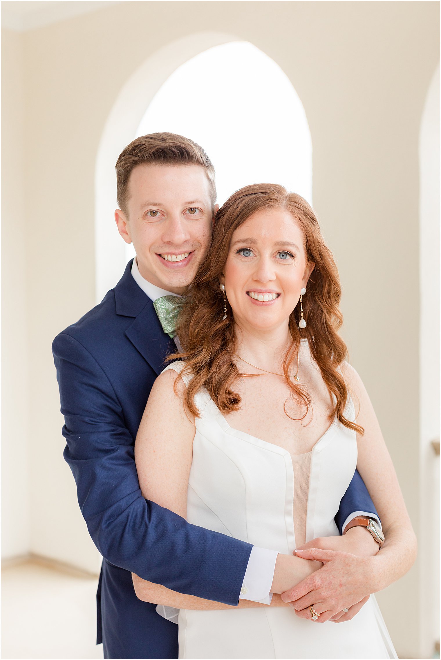 bride and groom hug on balcony at the Belmar Fishing Club