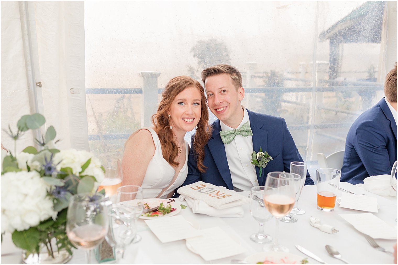 newlyweds sit at table together during NJ wedding reception