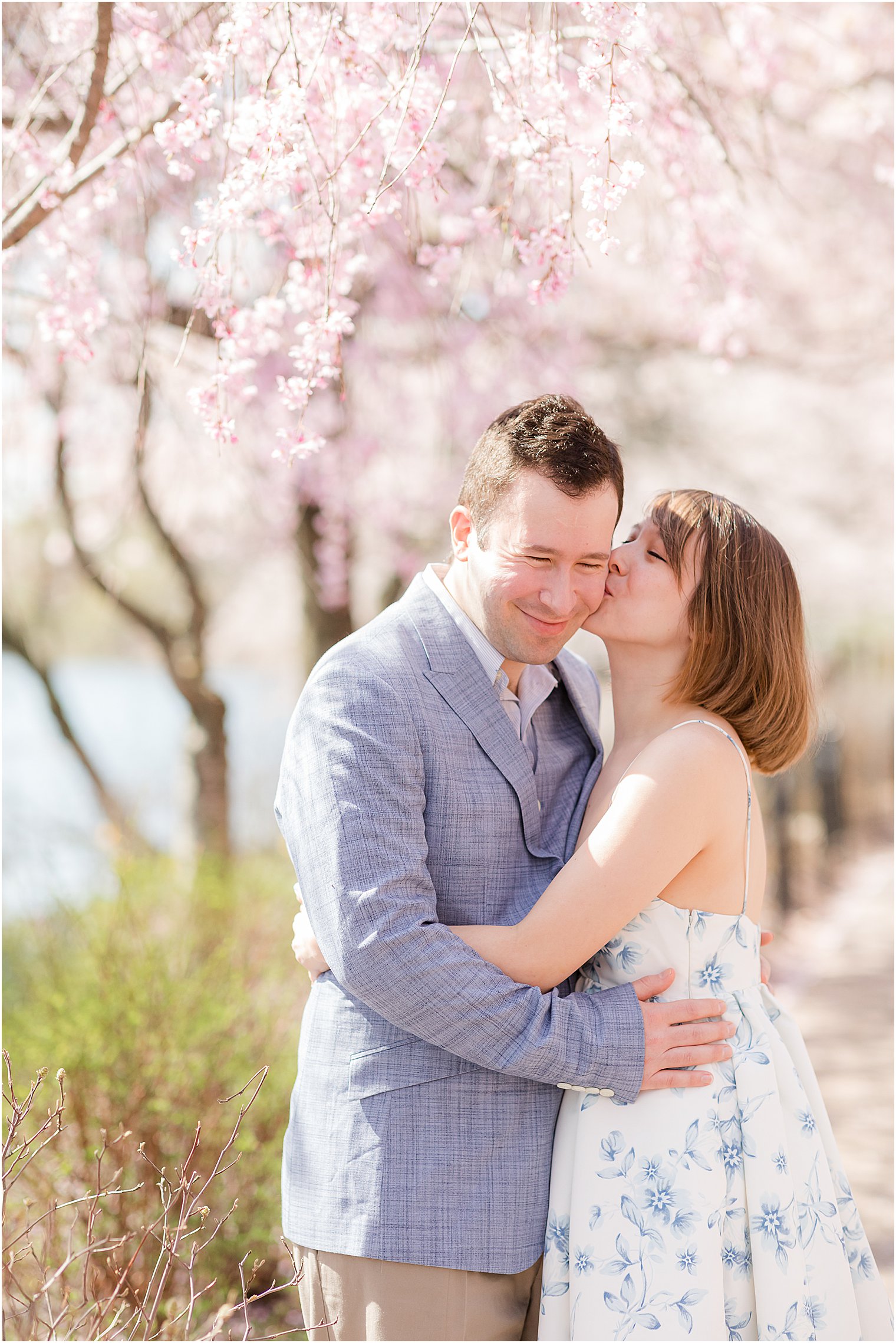 woman kisses fiancé's cheek during Branch Brook Park spring engagement photos