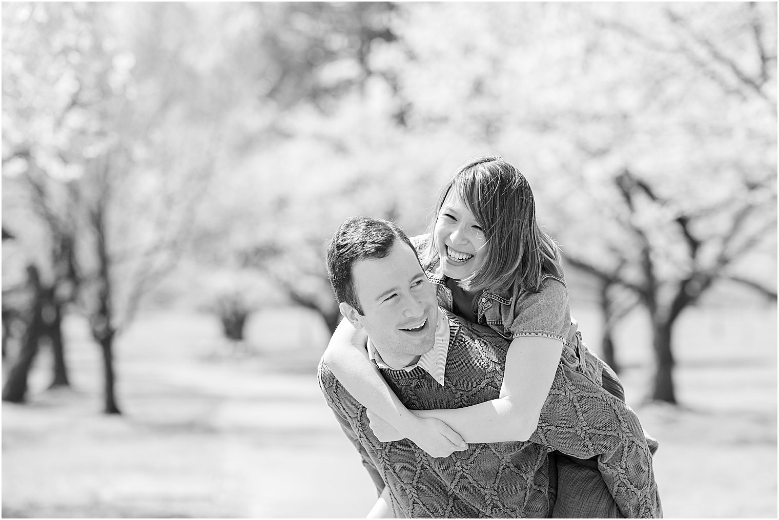 man gives fiancee piggy back ride during spring photos
