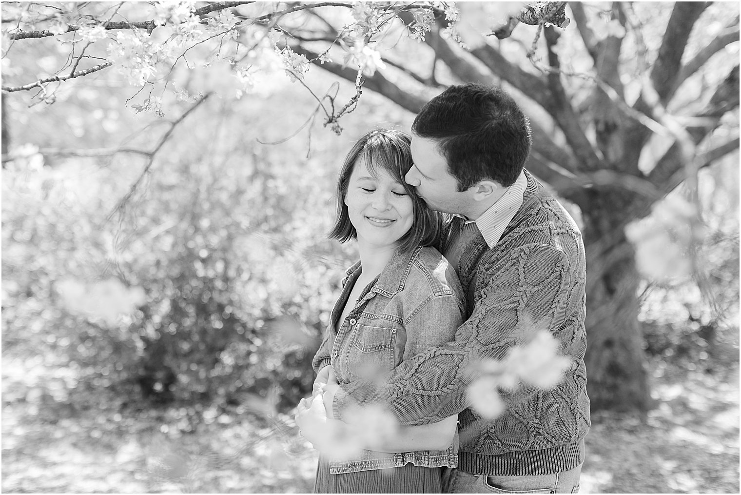 man hugs fiancee from behind during spring engagement session