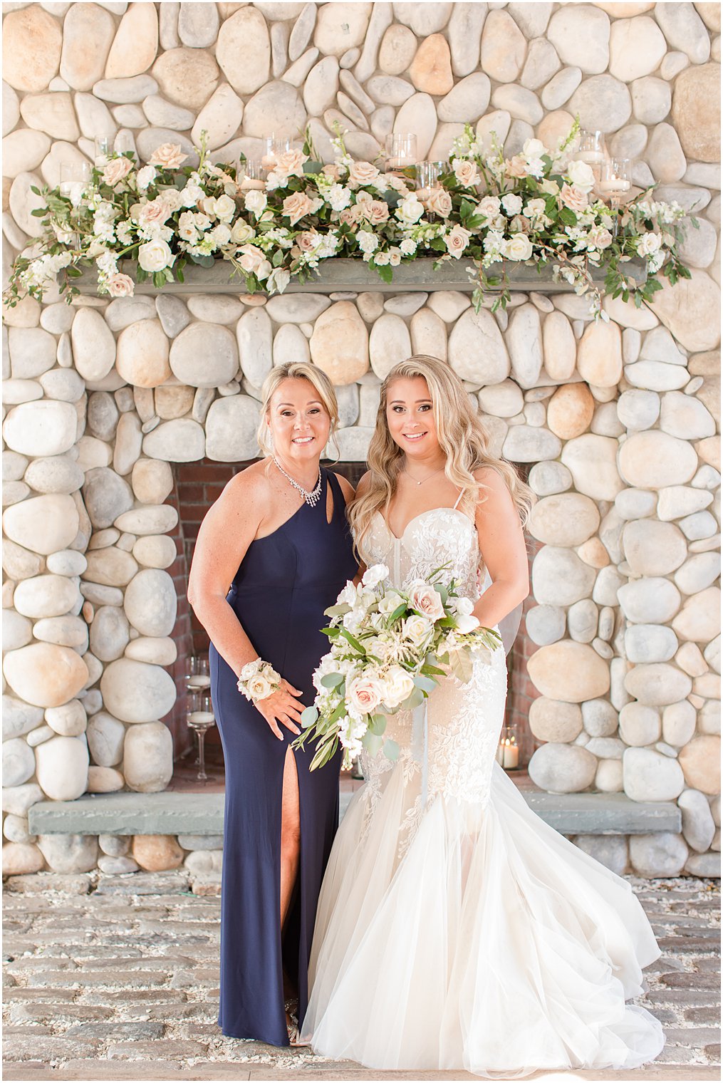 Bride with her mom on wedding day by stone fireplace
