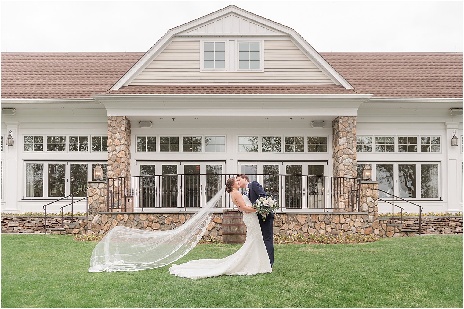 newlyweds kiss on front lawn in front of Indian Trail Club