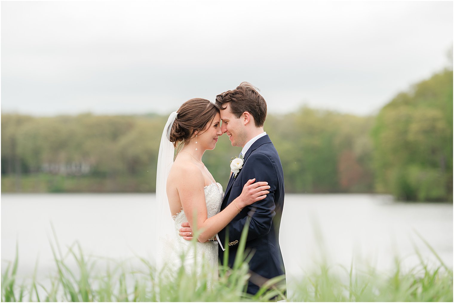 bride and groom hug by lake in Franklin Lakes, New Jersey