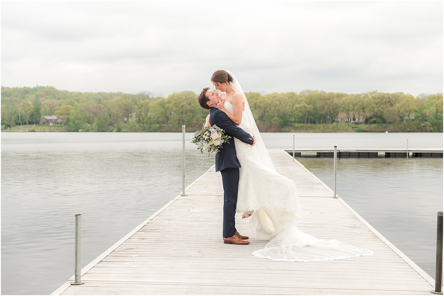 groom lifts bride on dock at Indian Trail Club