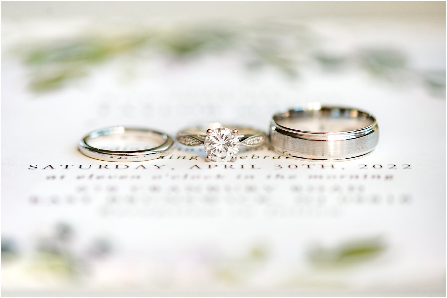 wedding rings rest on spring invitations 