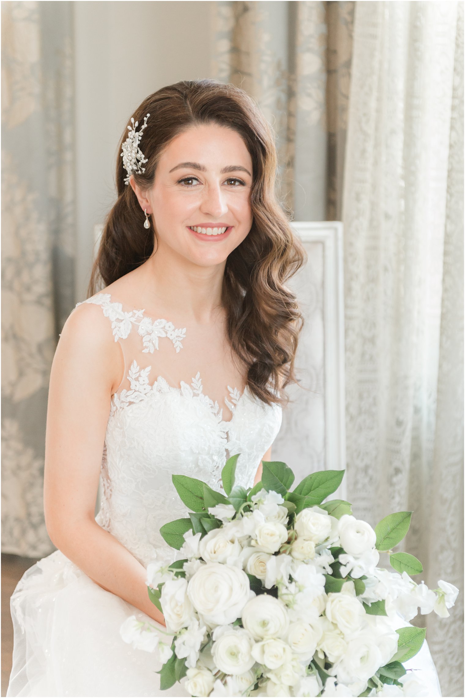 bride sits in chair holding bouquet in Park Chateau Estate bridal suite