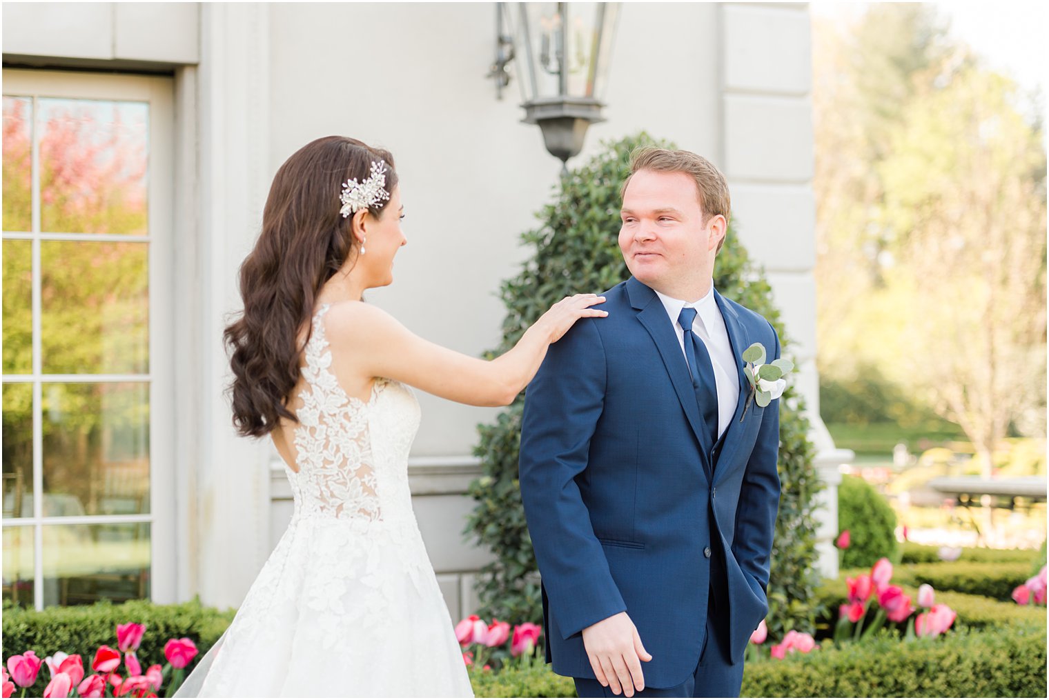 bride taps groom on shoulder during first look