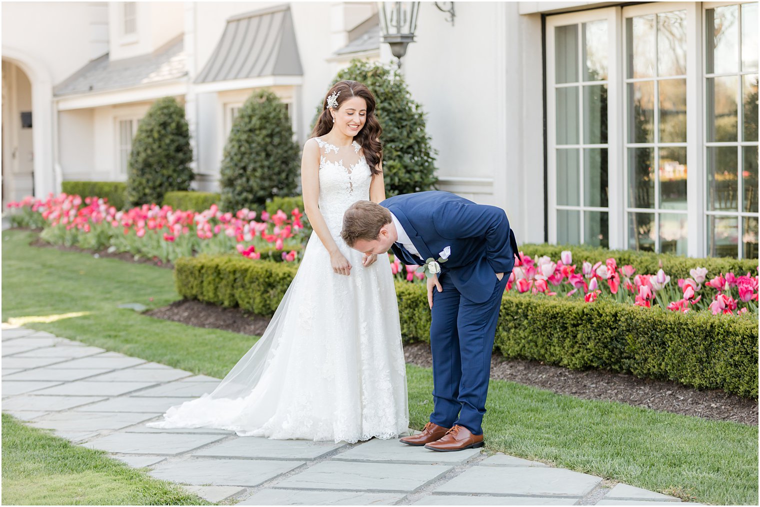 groom smiles and laughs leaning down during first look