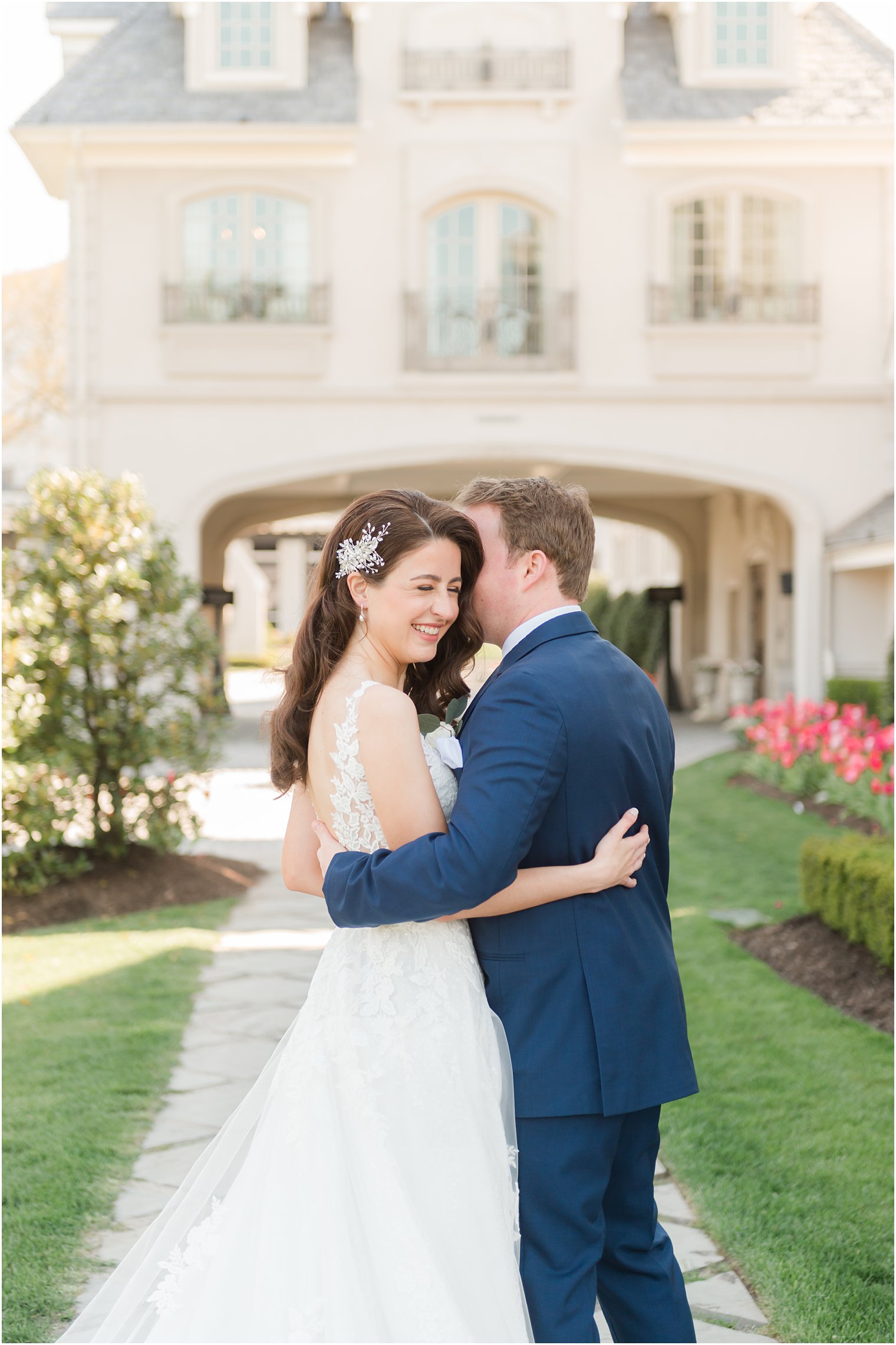 bride and groom hug outside main building of Park Chateau Estate