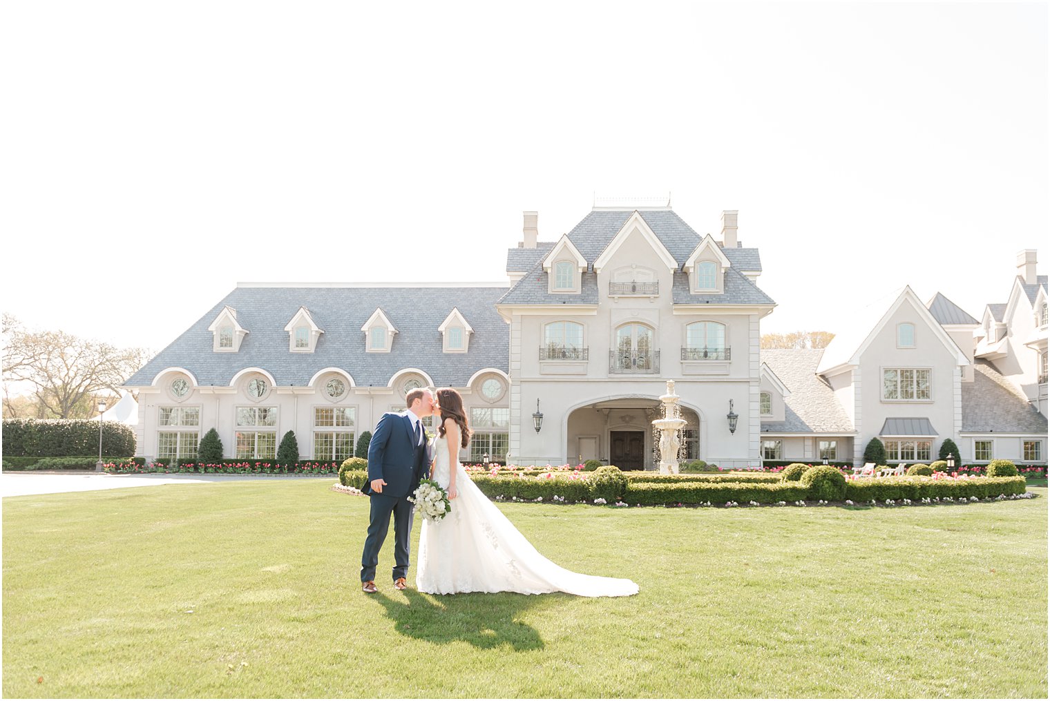 groom leans to kiss bride outside Park Chateau Estate