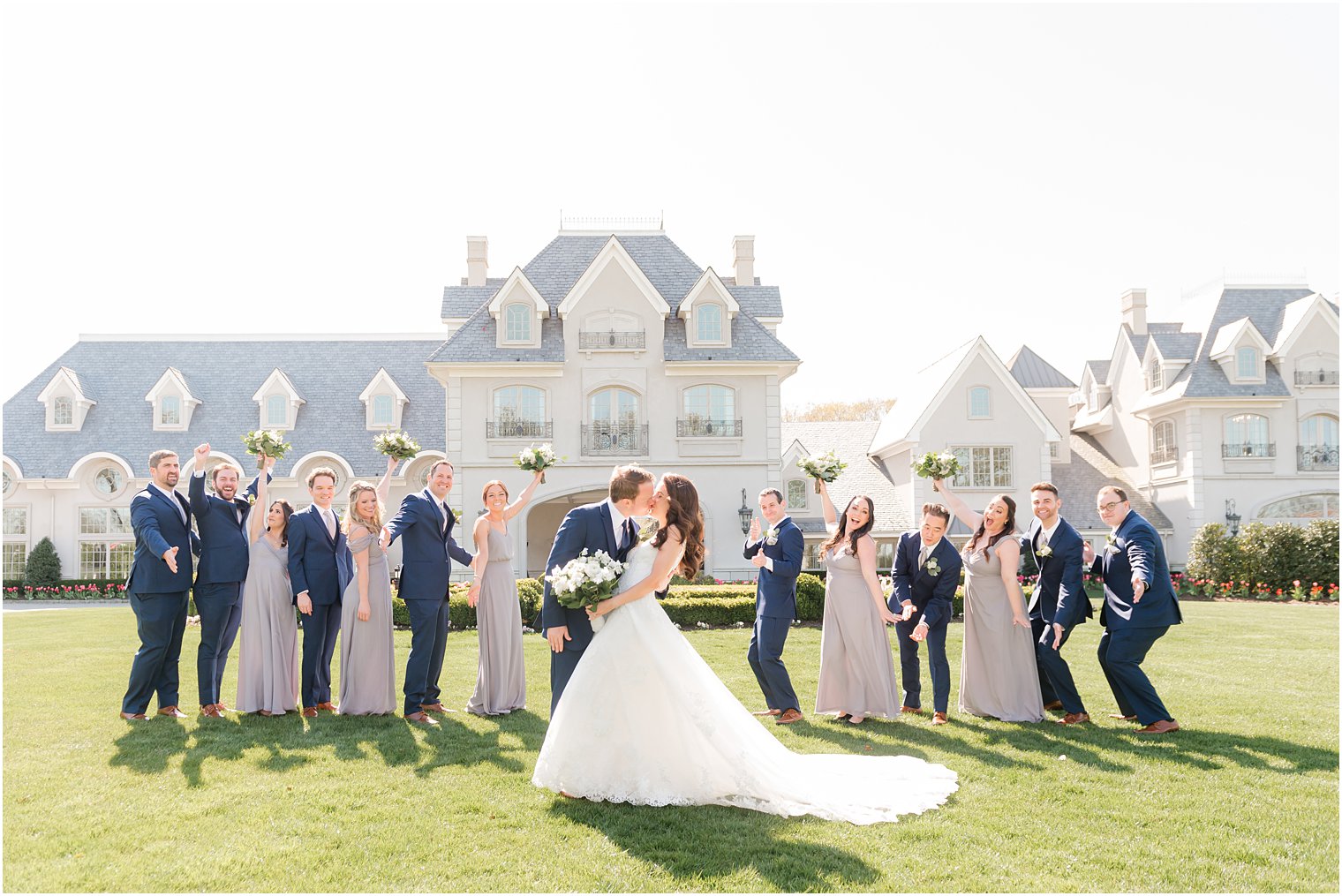 bride and groom kiss in front of bridal party
