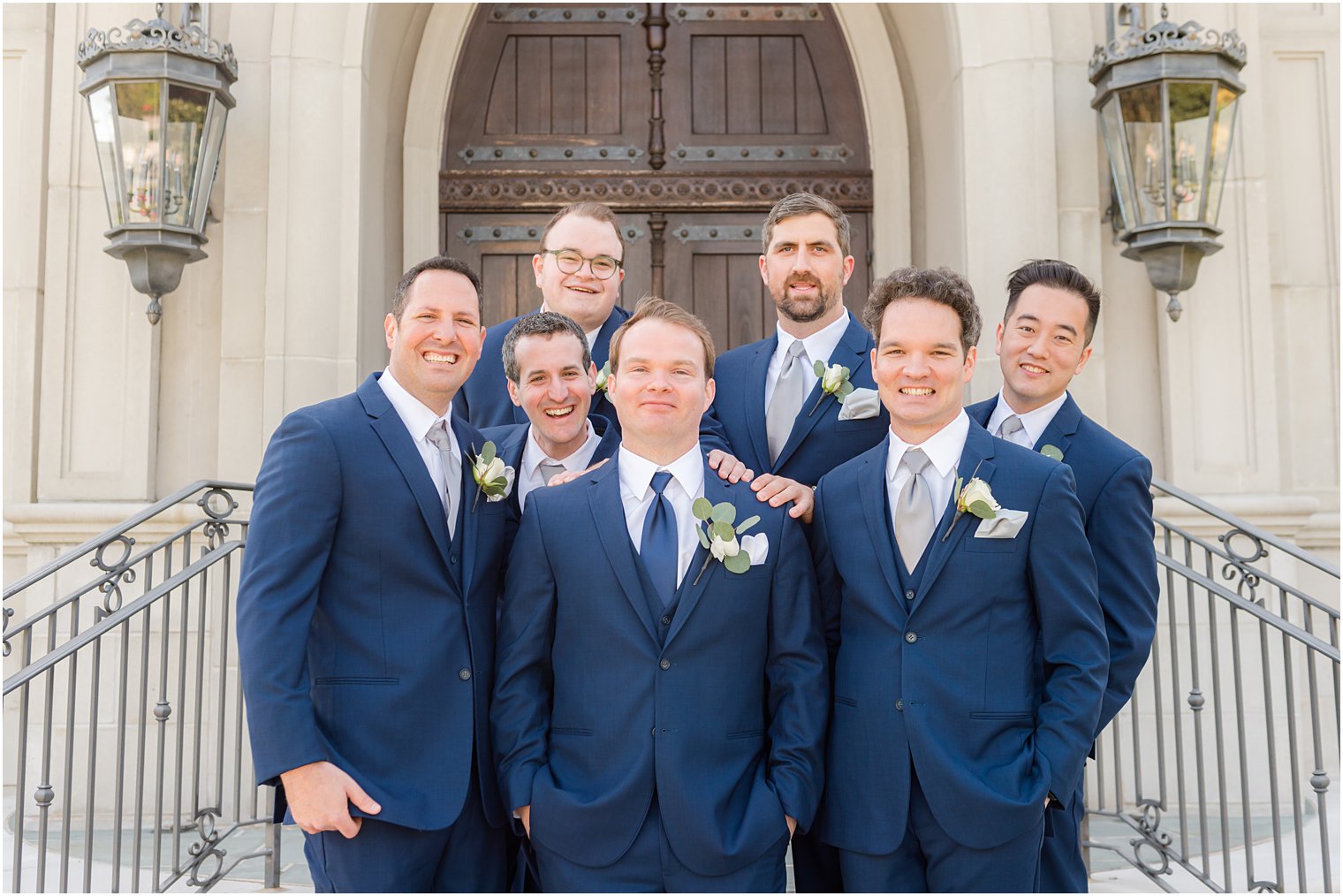 groom poses with groomsmen in navy suit at chapel of Park Chateau