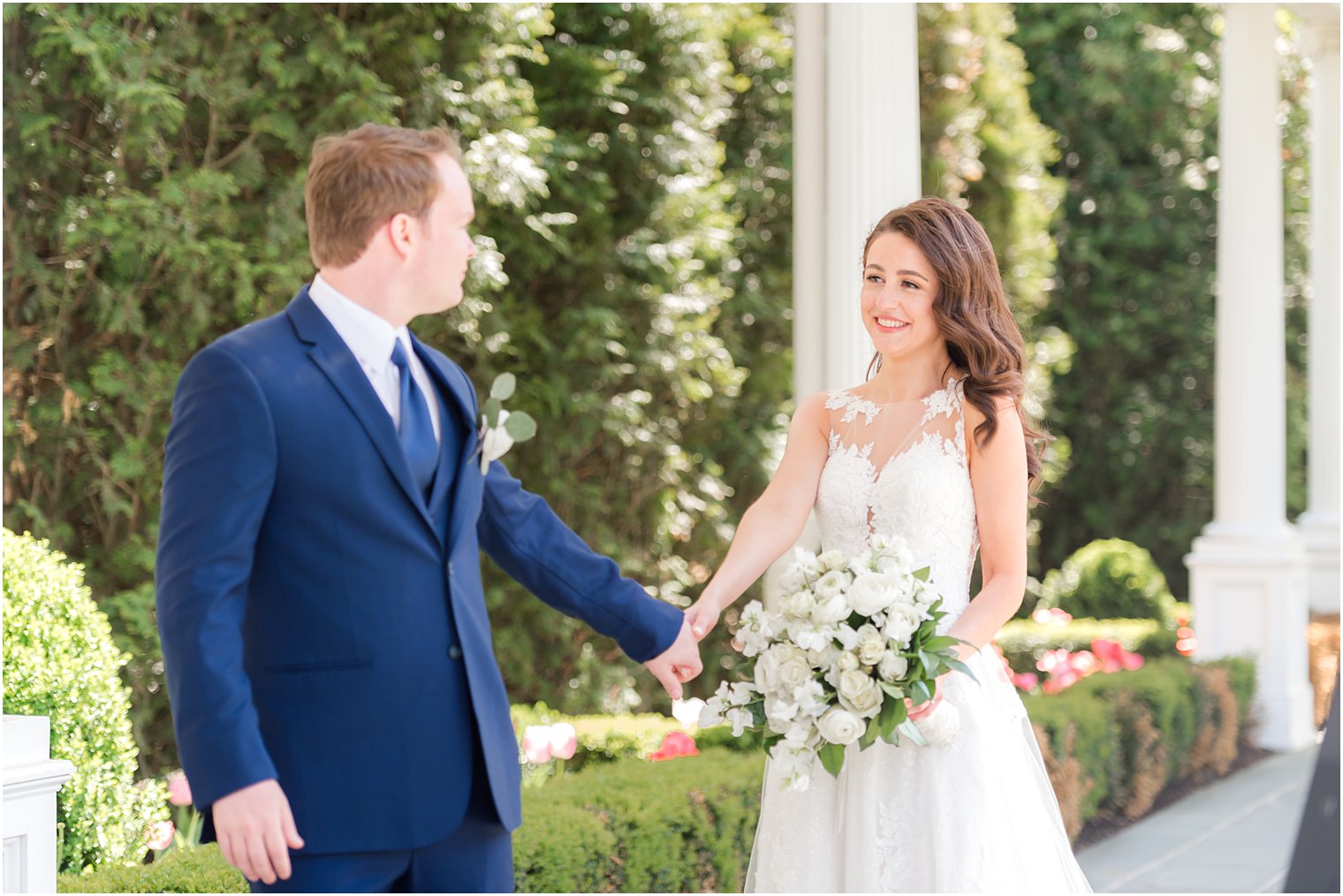 groom leads bride through Park Chateau during spring wedding photos