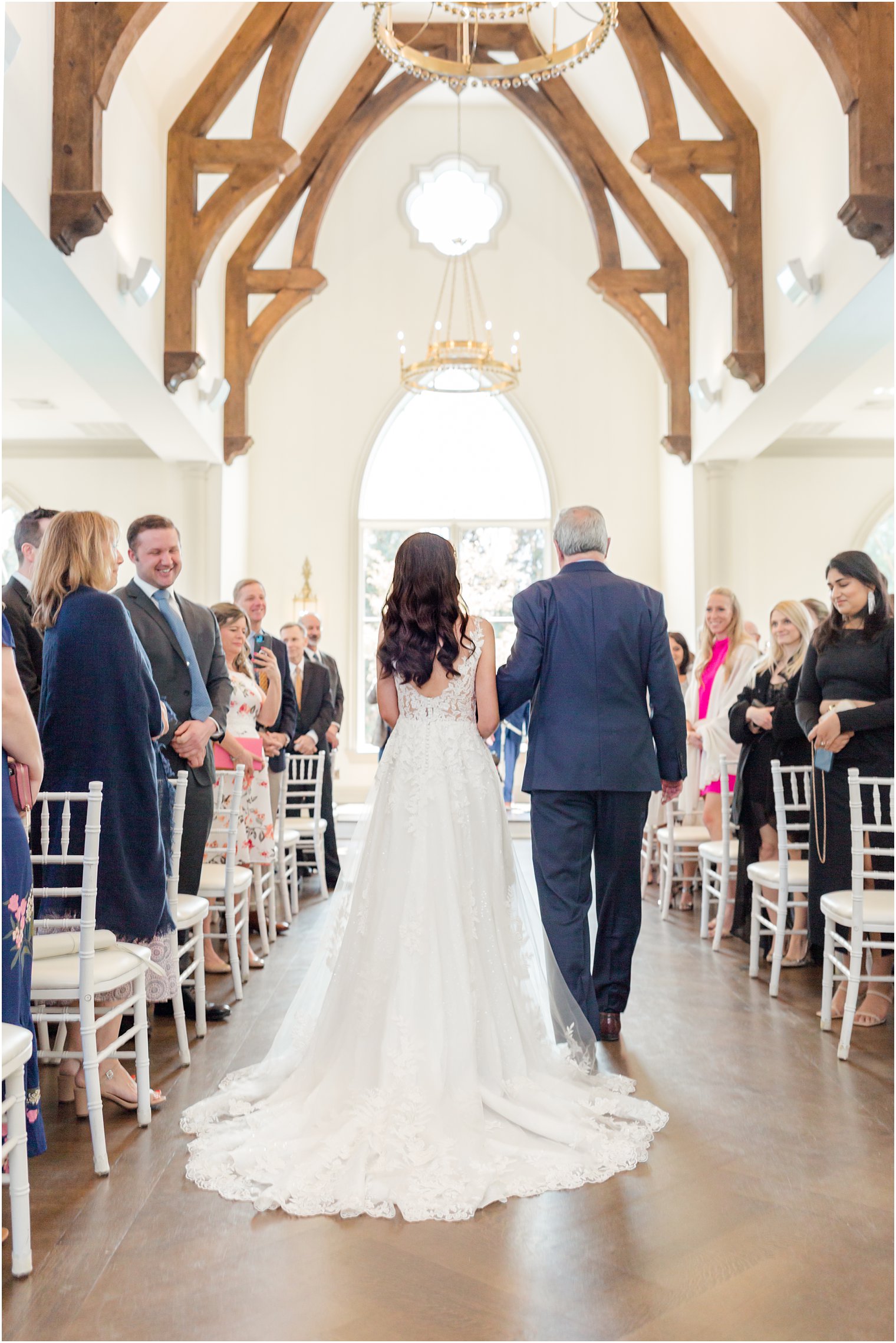 bride walks down the aisle with dad during Park Chateau chapel ceremony