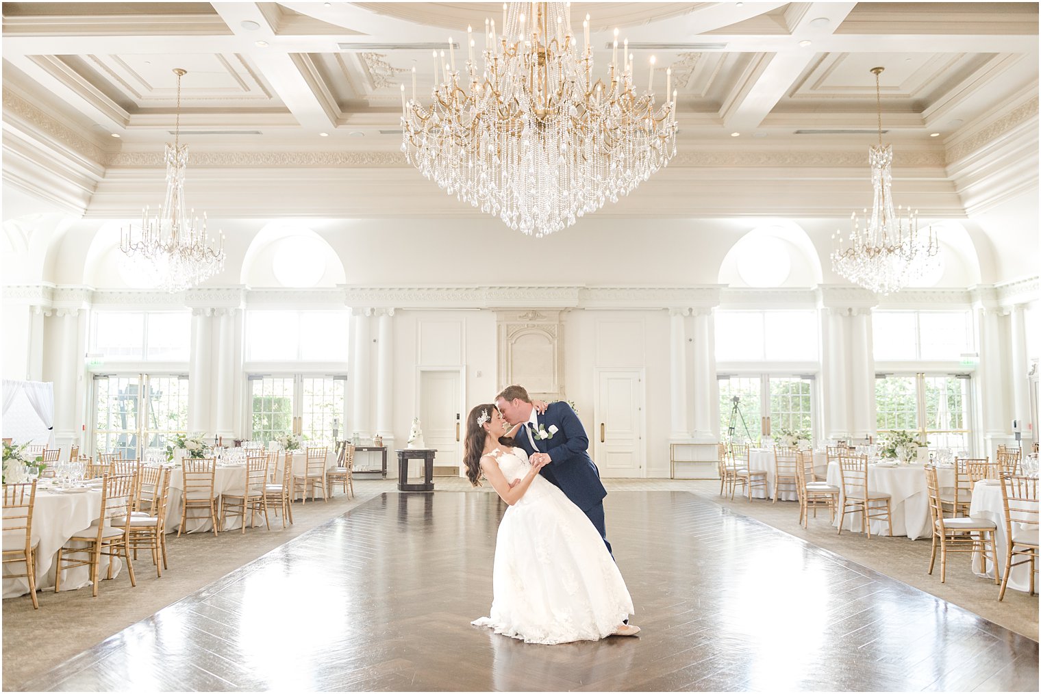 newlyweds kiss under chandelier in Park Chateau Estate