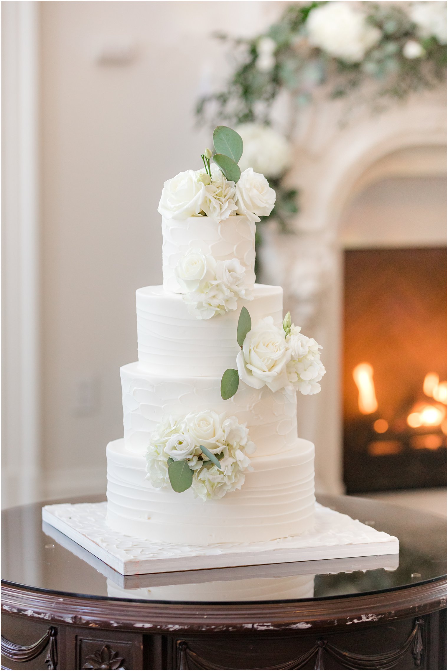 tiered white wedding cake with flowers winding down the side