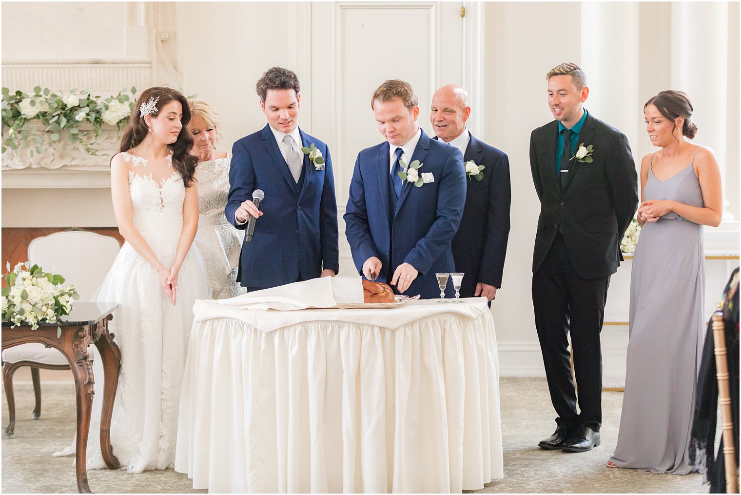 couple slices bread during wedding reception 