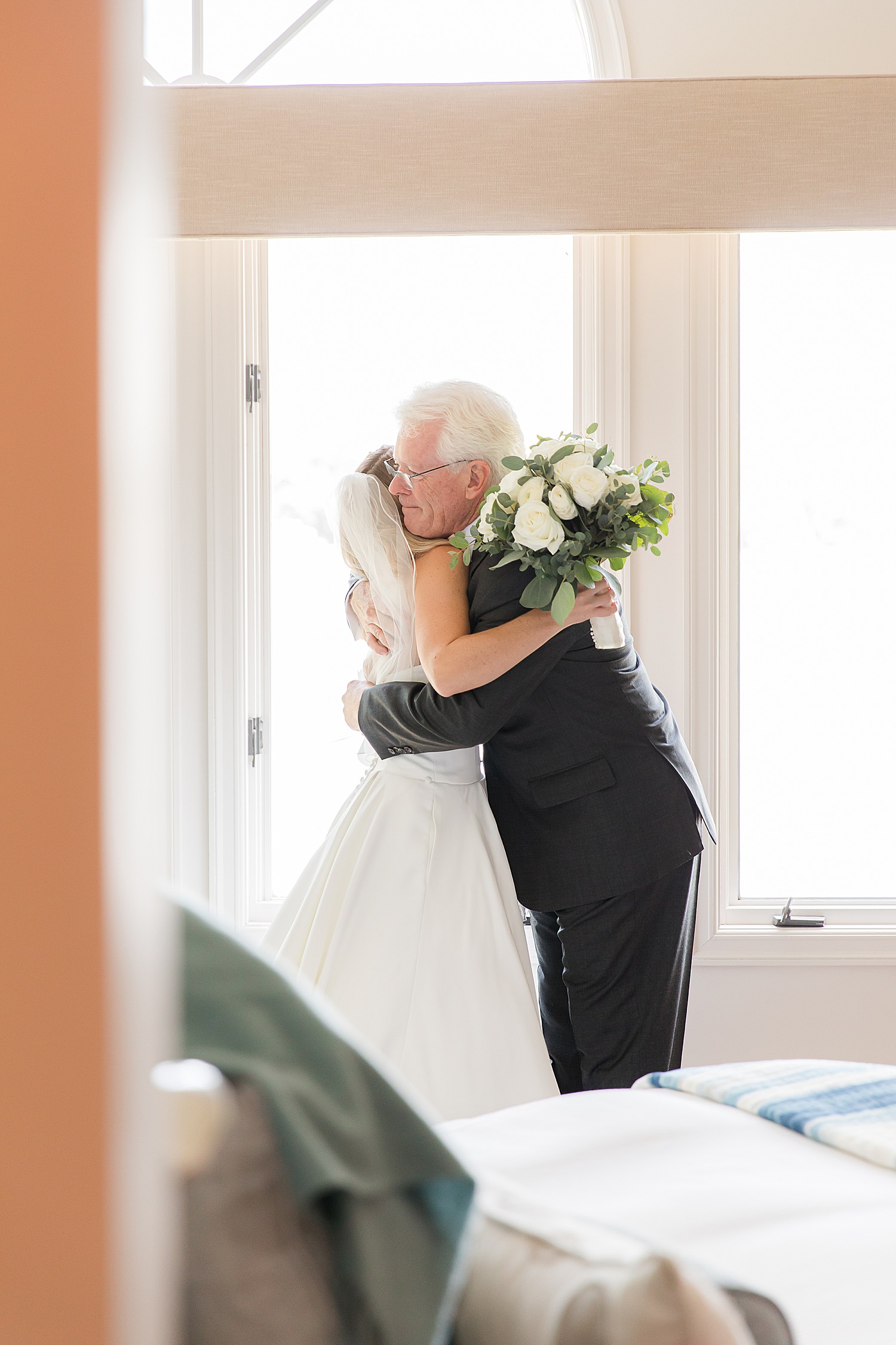 dad hugs his daughter during first look before wedding ceremony