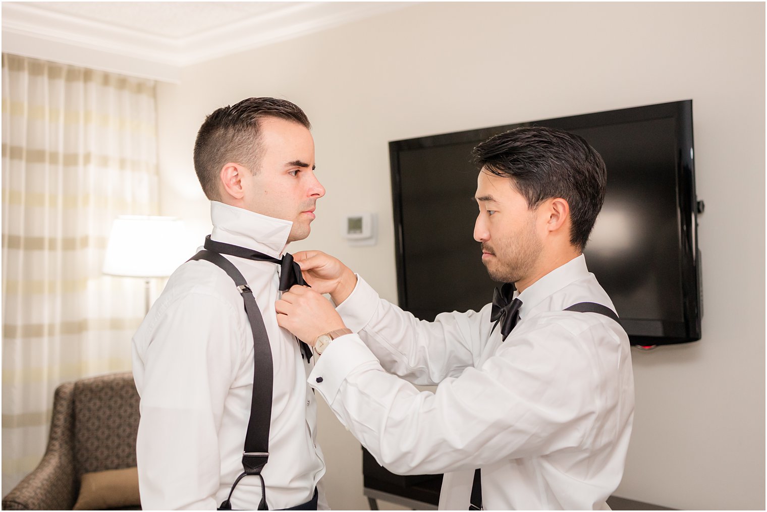 groomsman adjust bow tie for groom before wedding at Indian Trail Club 