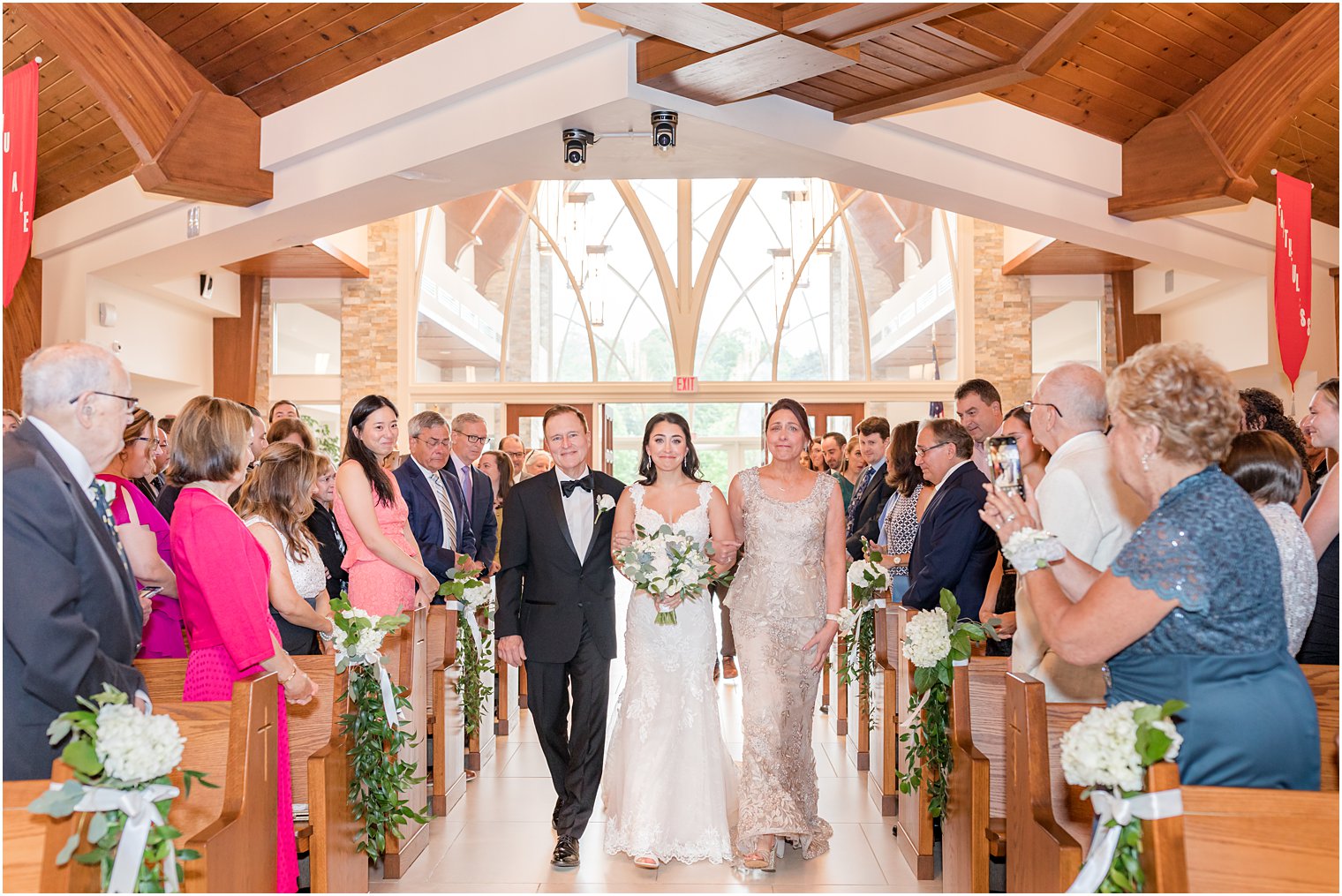 bride enters traditional church wedding ceremony in New Jersey with parents 