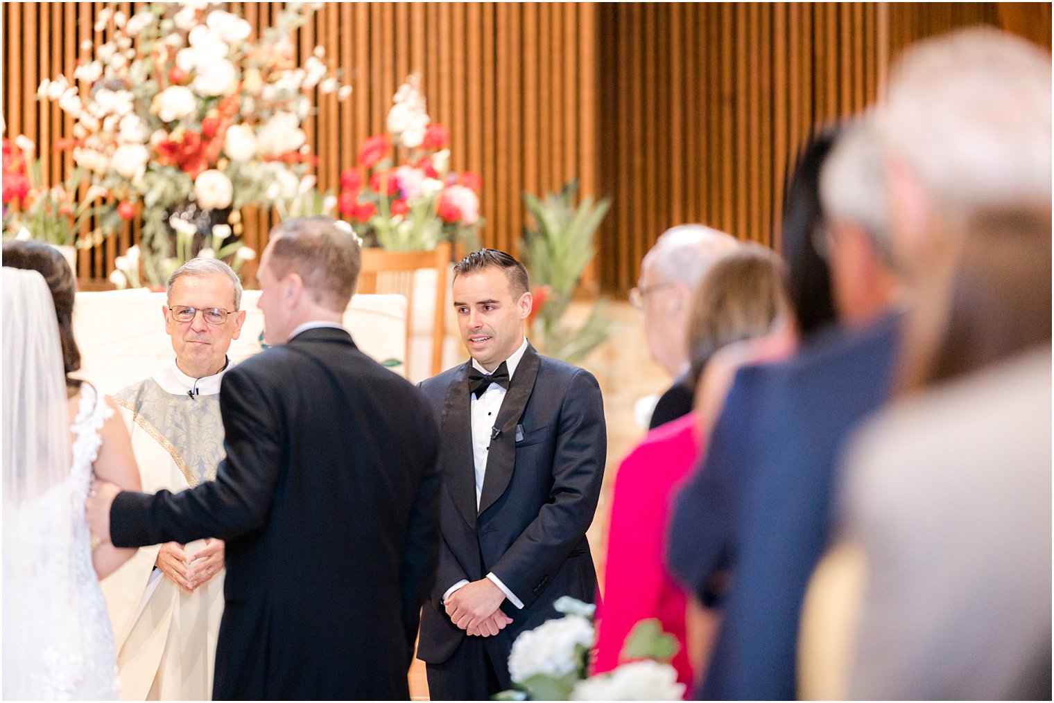 groom watches bride approach alter for traditional church wedding ceremony in New Jersey