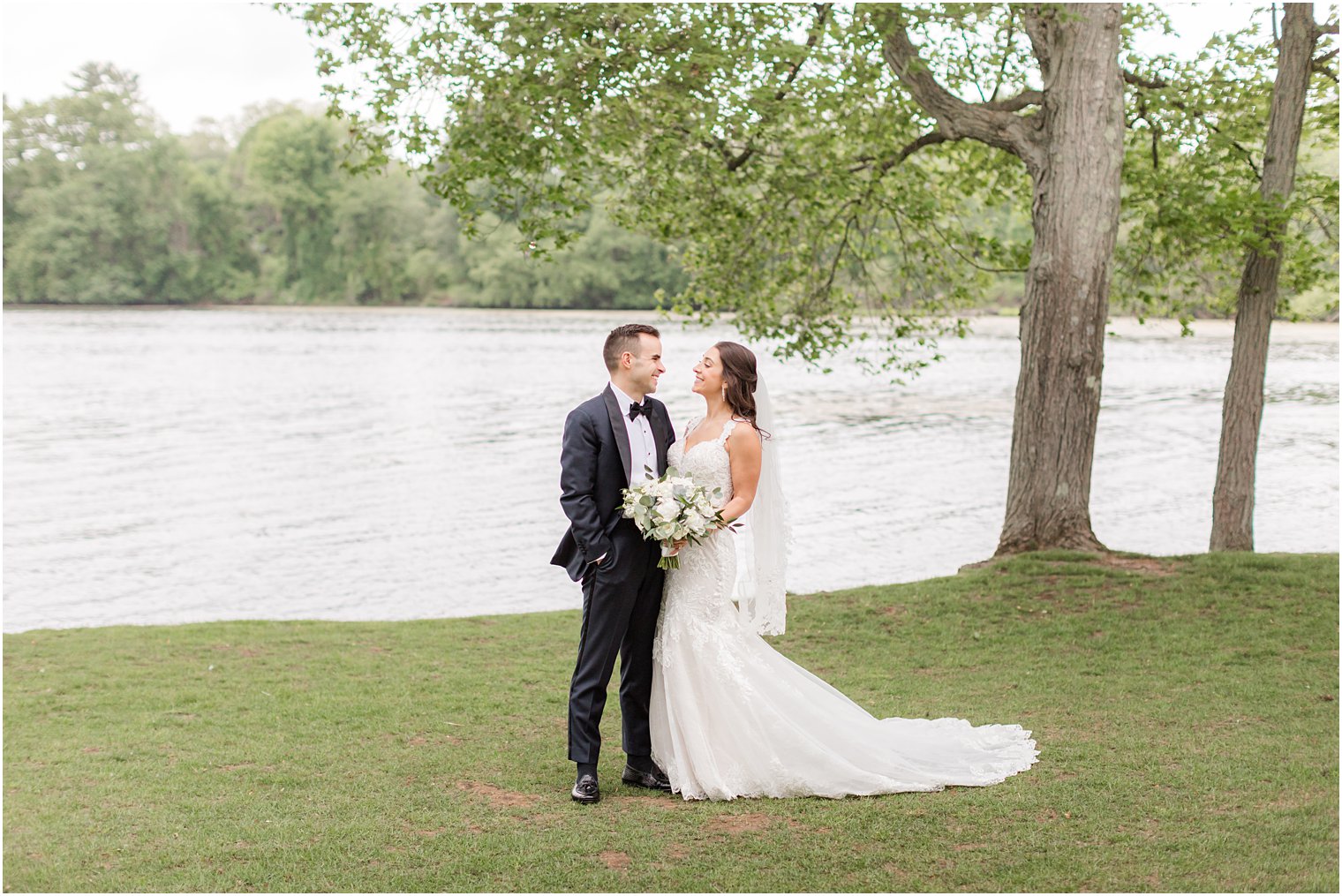 newlyweds pose by lake at Indian Trail Club 