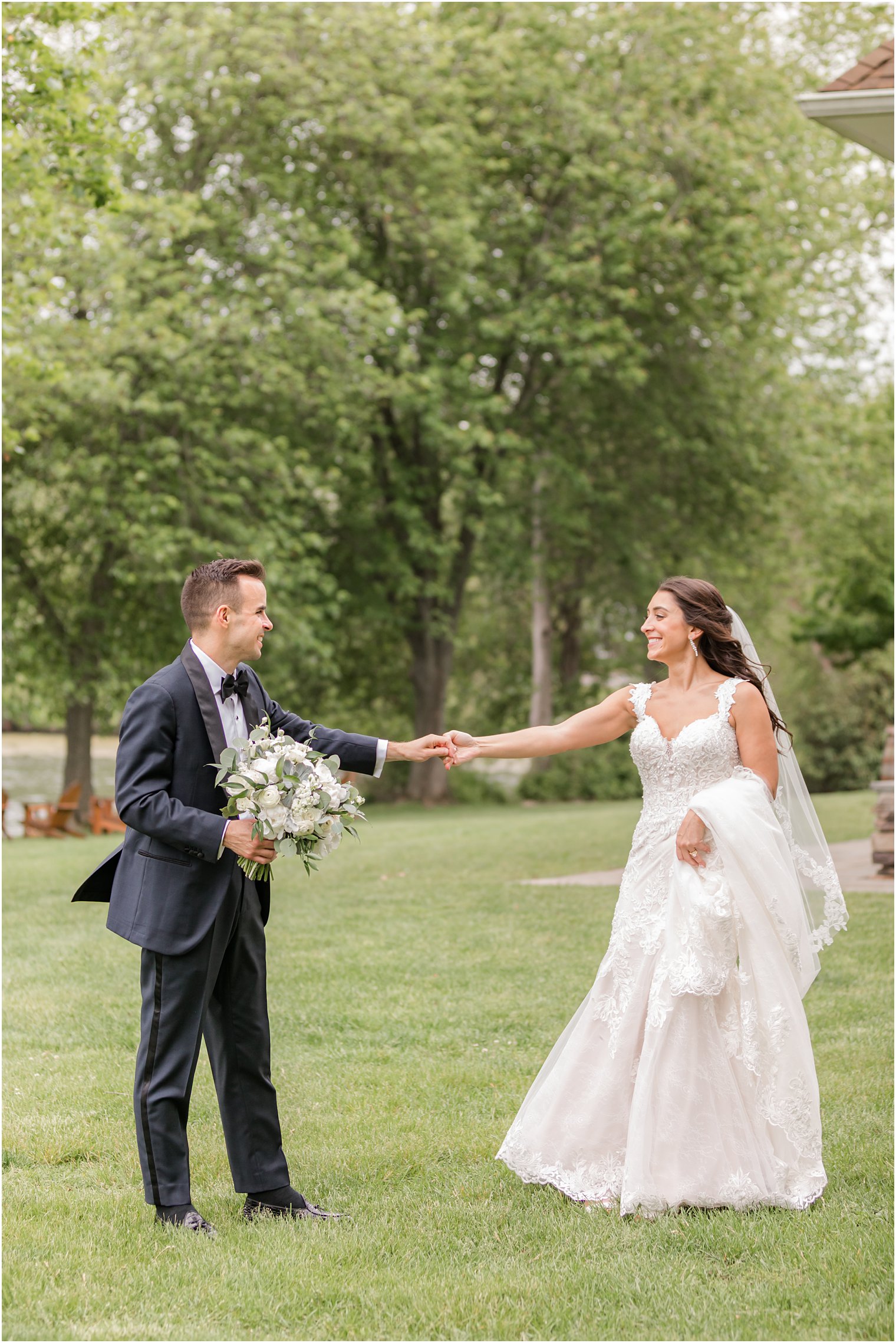 groom shows off bride's wedding dress