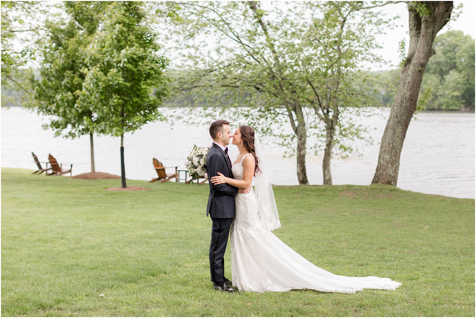 newlyweds kiss by lake at Indian Trail Club