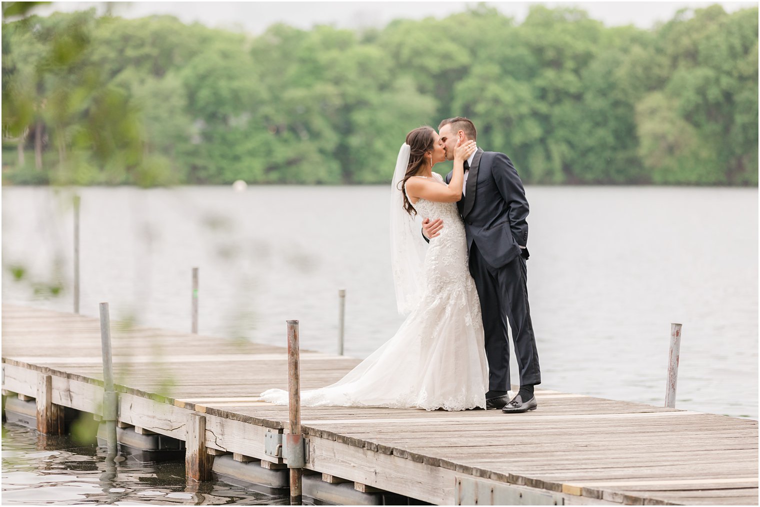 newlyweds kiss on dock at Indian Trail Club