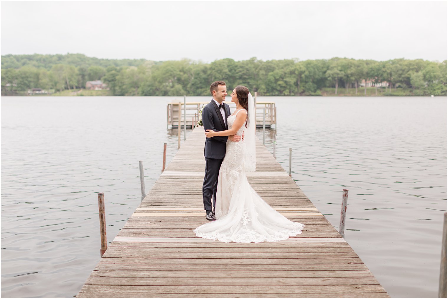 bride and groom hug each other on dock at Indian Trail Club