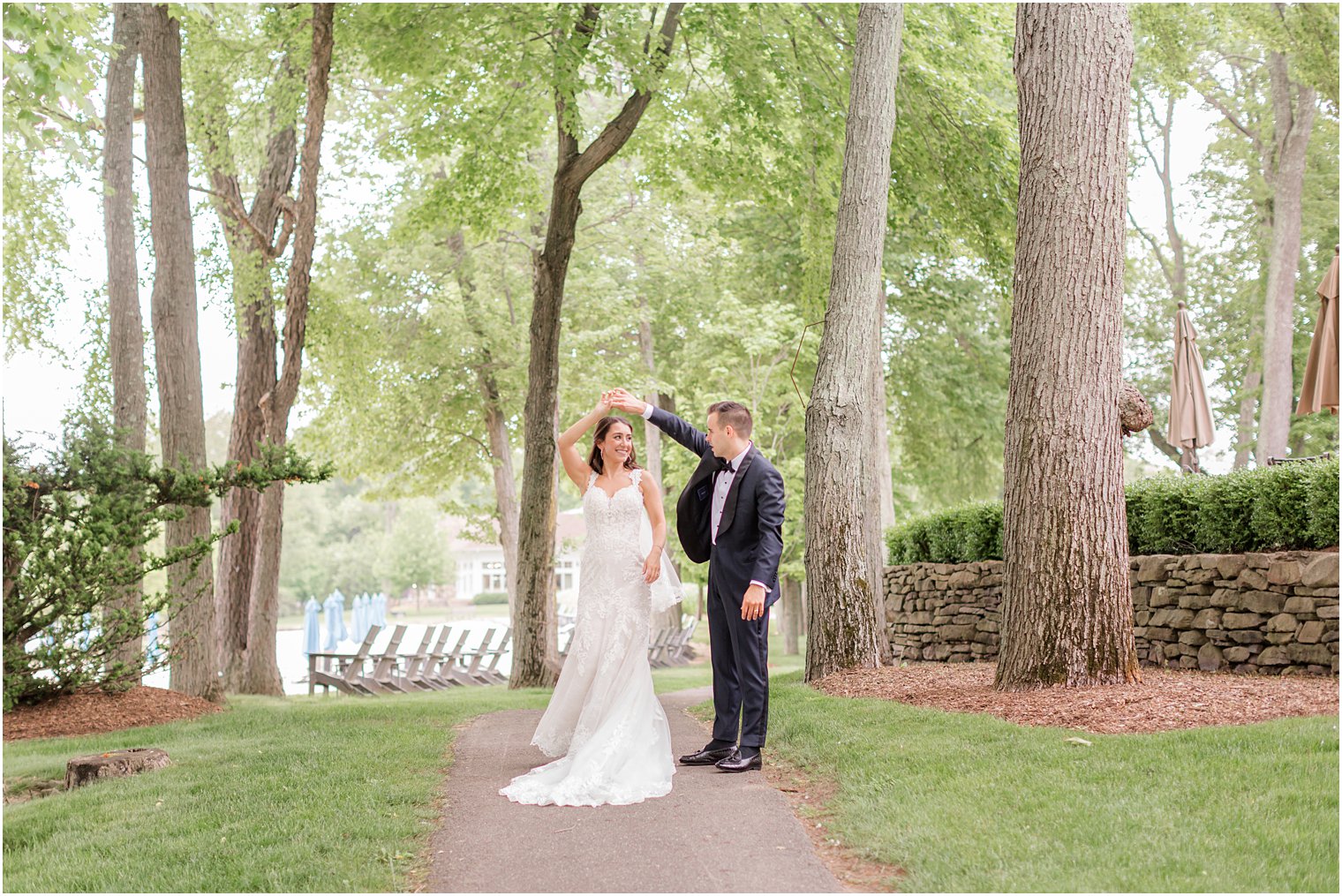 groom twirls bride on path at Indian Trail Club