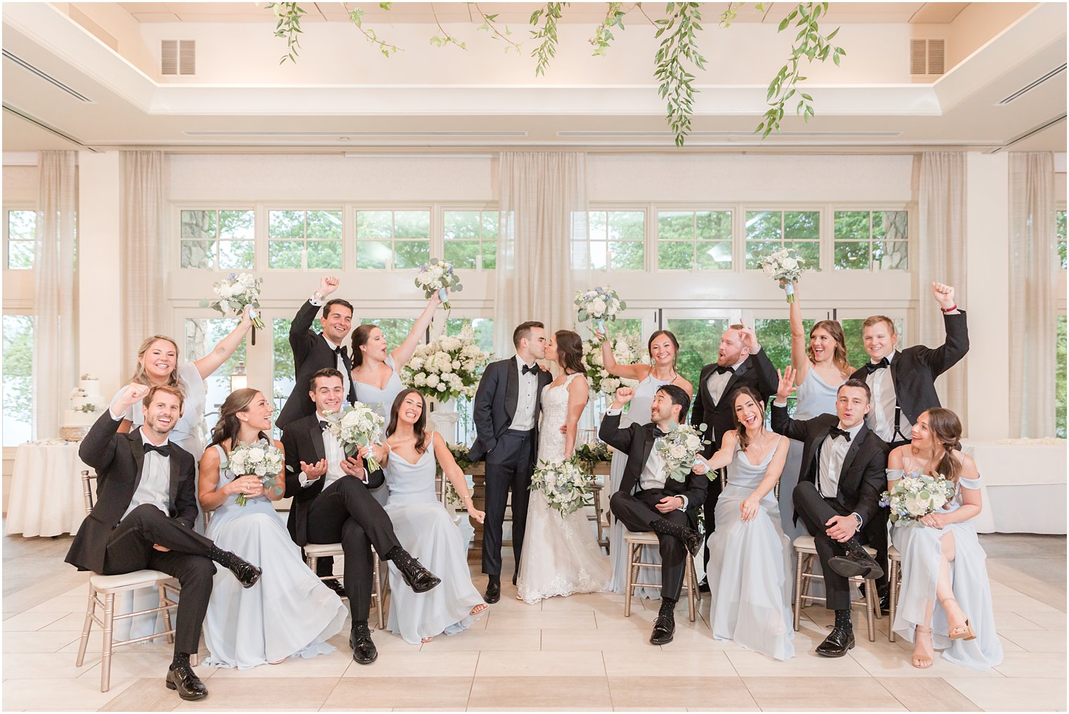 newlyweds kiss while bridal party surrounds them at Indian Trail Club