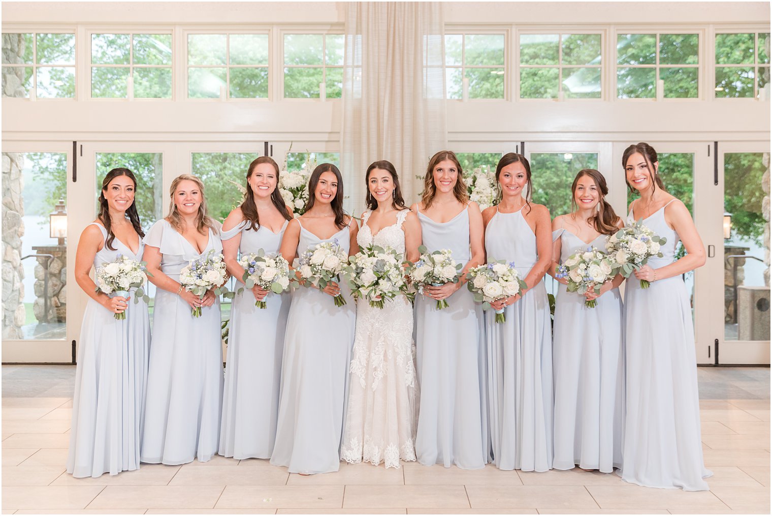 bride stands with bridesmaids in pale blue gowns at Indian Trail Club